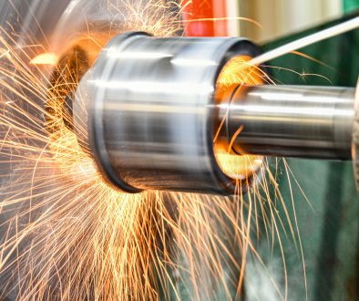 The abrasive wheel removes the excess metal layer, sparks fly to