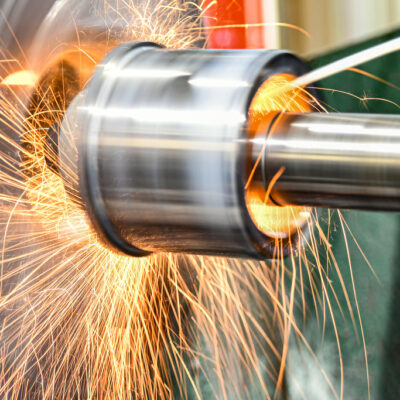 The abrasive wheel removes the excess metal layer, sparks fly to