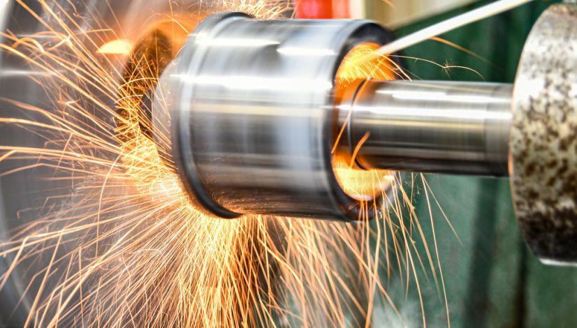The abrasive wheel removes the excess metal layer, sparks fly to