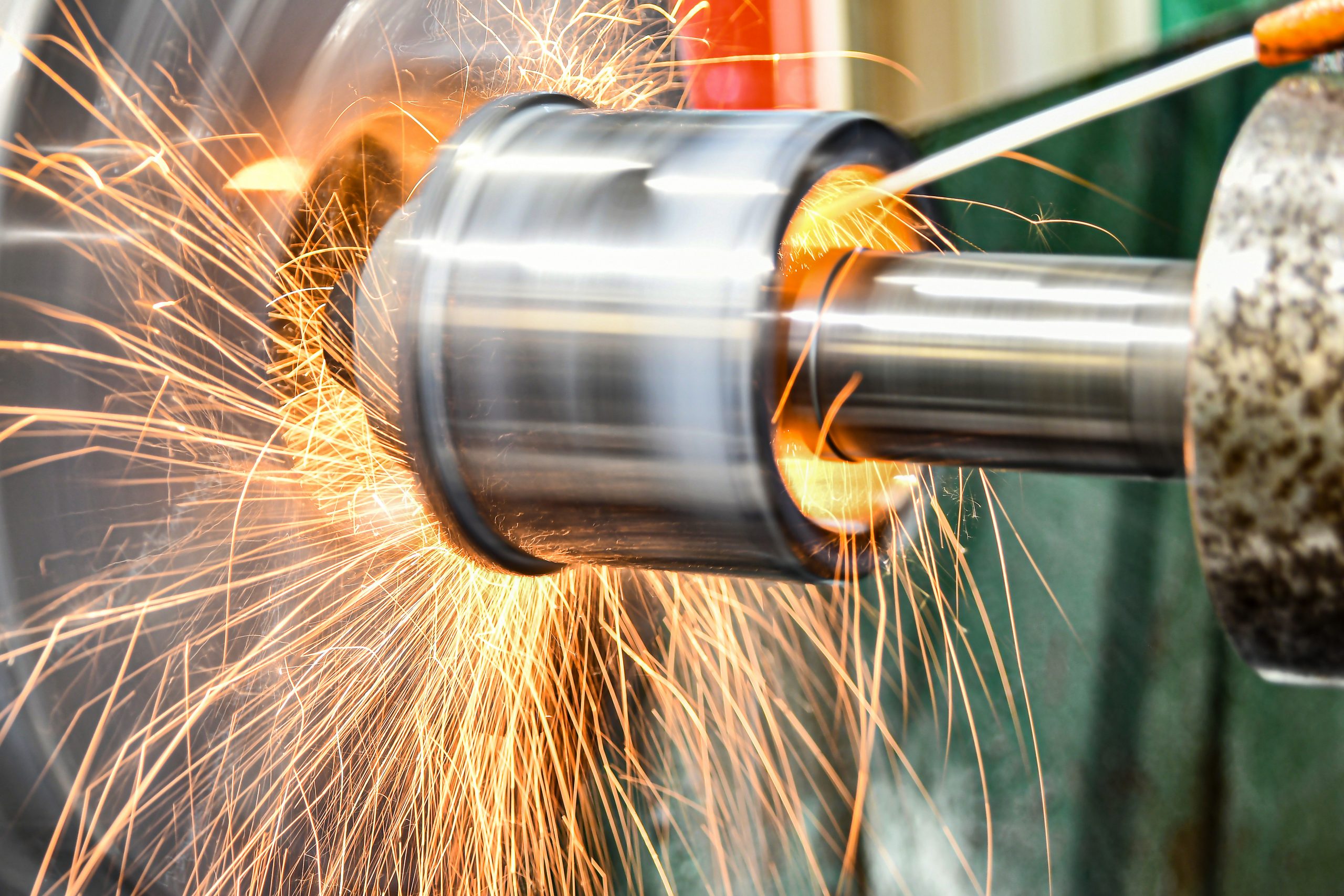 The abrasive wheel removes the excess metal layer, sparks fly to