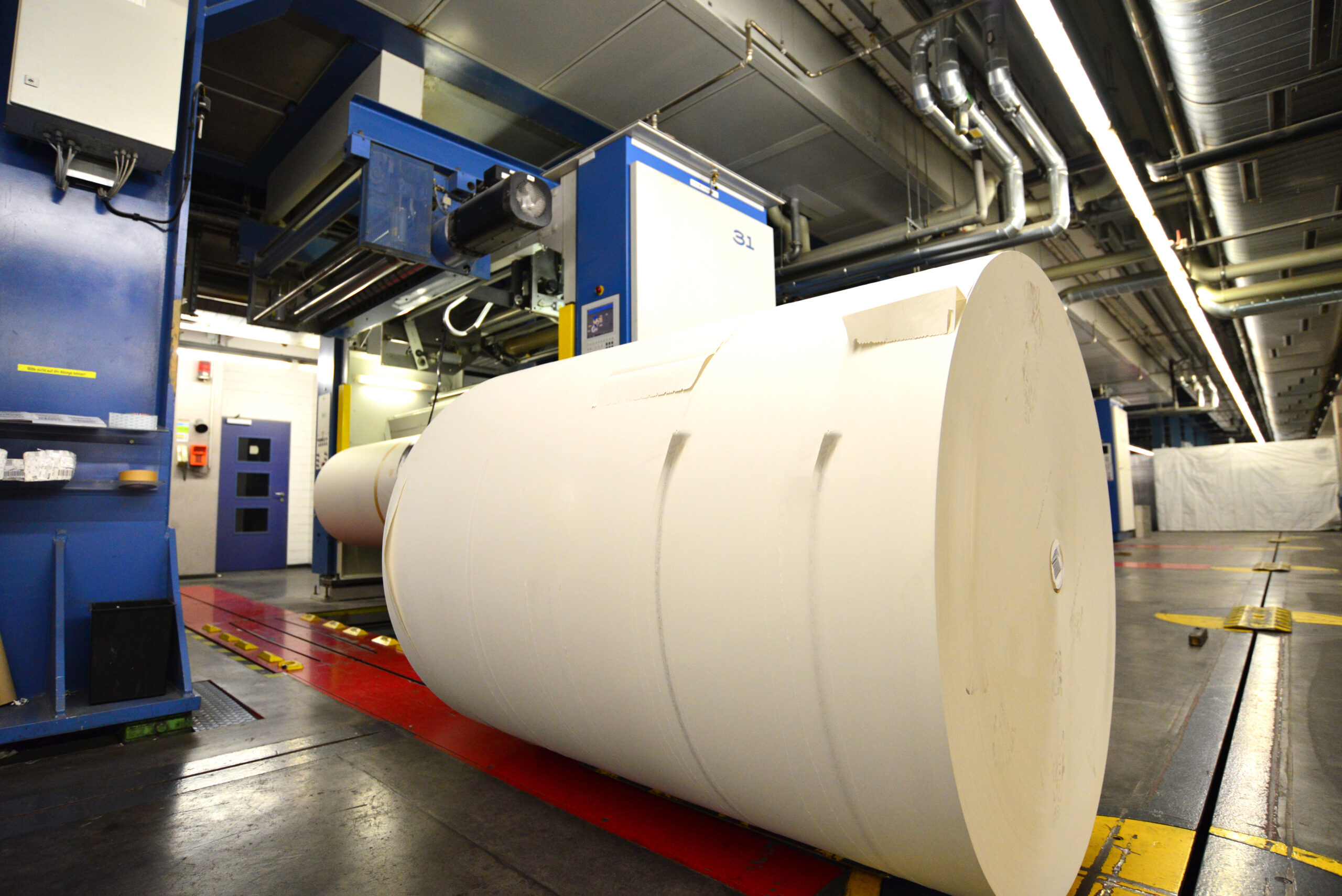 paper roll for printing in front of a web offset printing machin