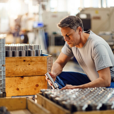 Steel worker examining finished products in a factory.