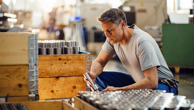 Steel worker examining finished products in a factory.